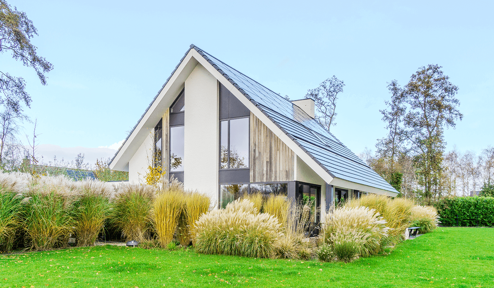 Modern minimalistisch woonhuis in Oranjewoud met verticale gevelelementen, keim-afwerking en grote glaspartijen.