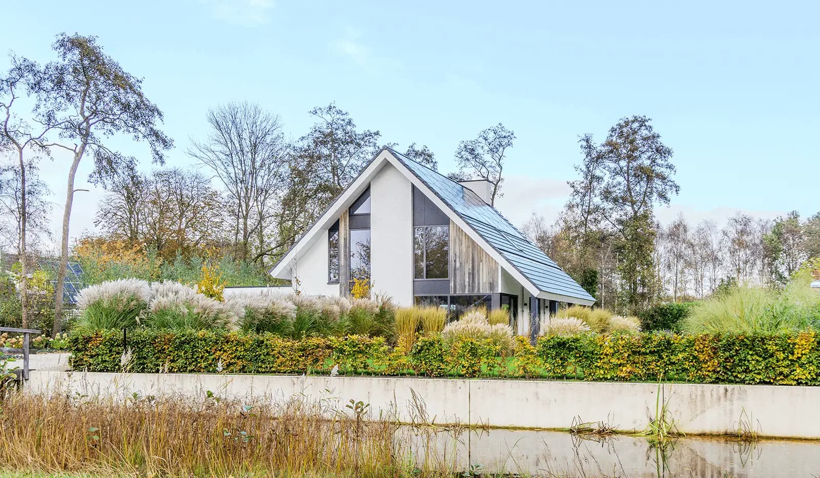 Modern minimalistisch woonhuis in Oranjewoud met verticale gevelelementen, keim-afwerking en grote glaspartijen.