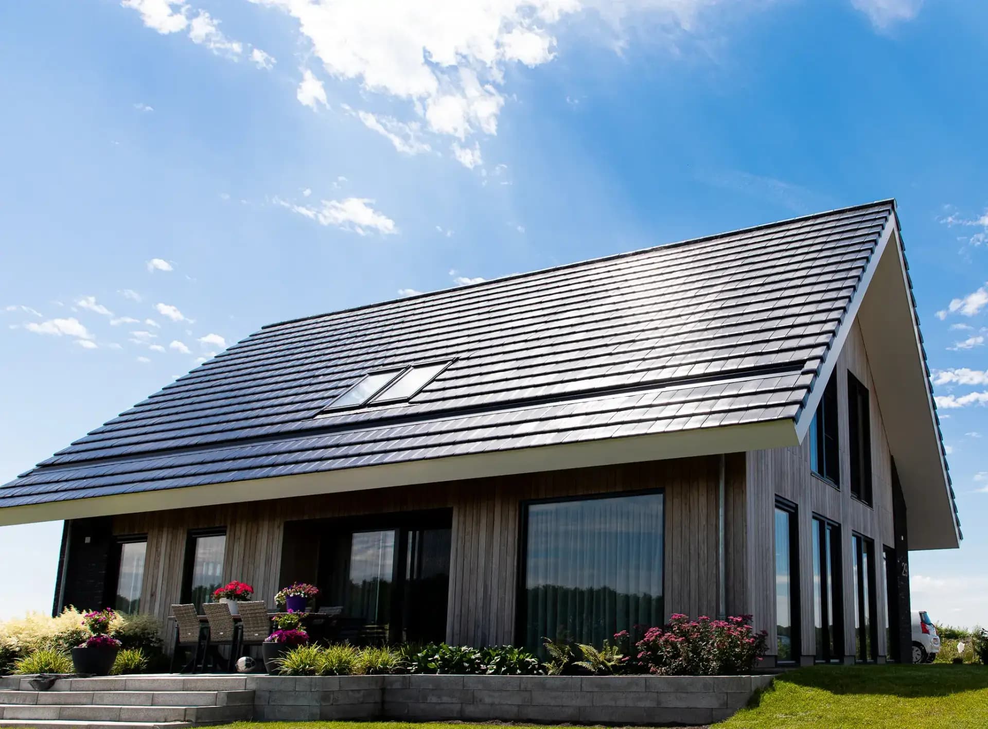 Schuurwoning op een kopkavel aan het Icarusblauwtje in Wolvega, in naturel hout met langformaat metselwerkaccenten en panoramisch uitzicht op het water.