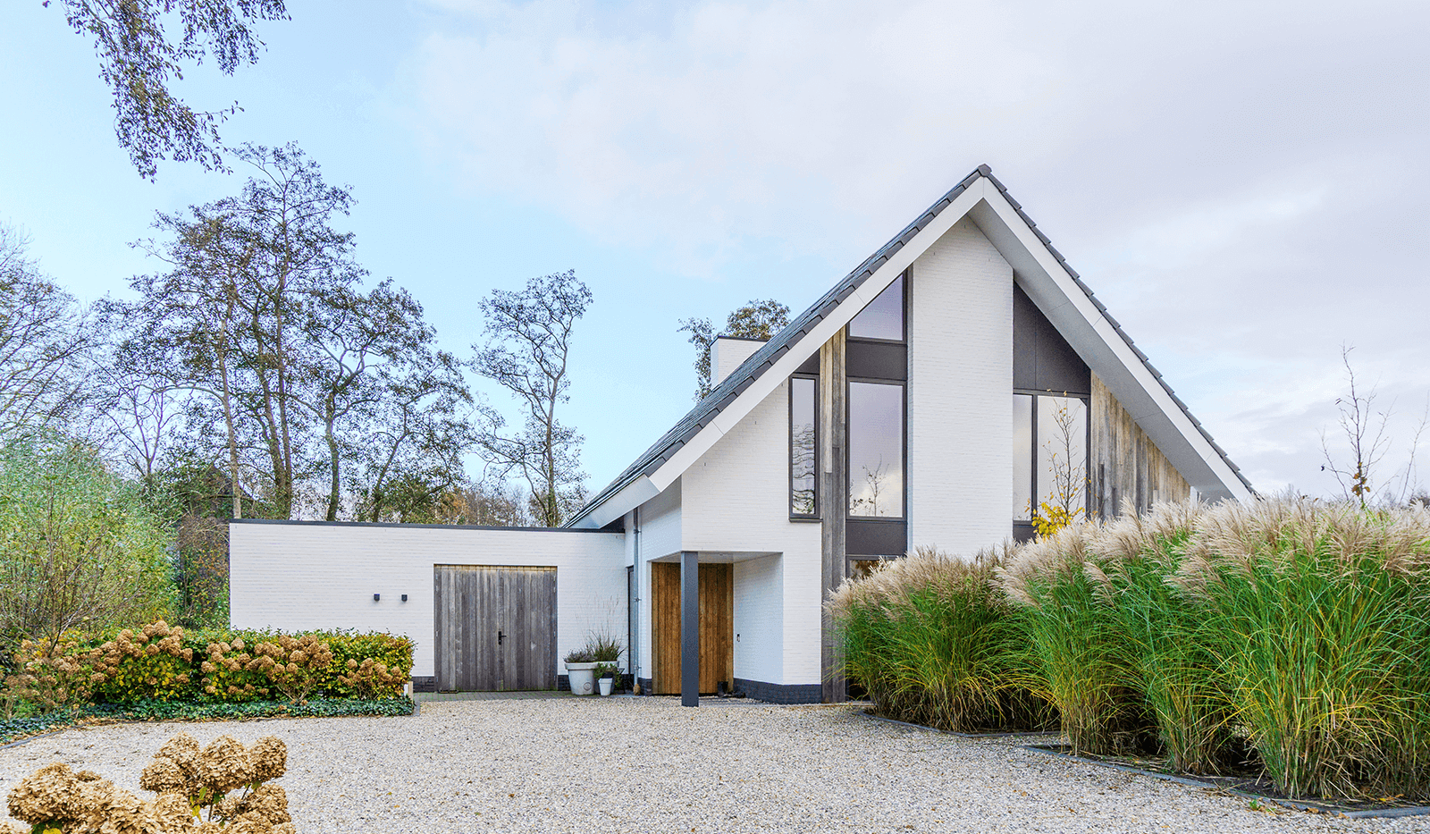 Modern minimalistisch woonhuis in Oranjewoud met verticale gevelelementen, keim-afwerking en grote glaspartijen.